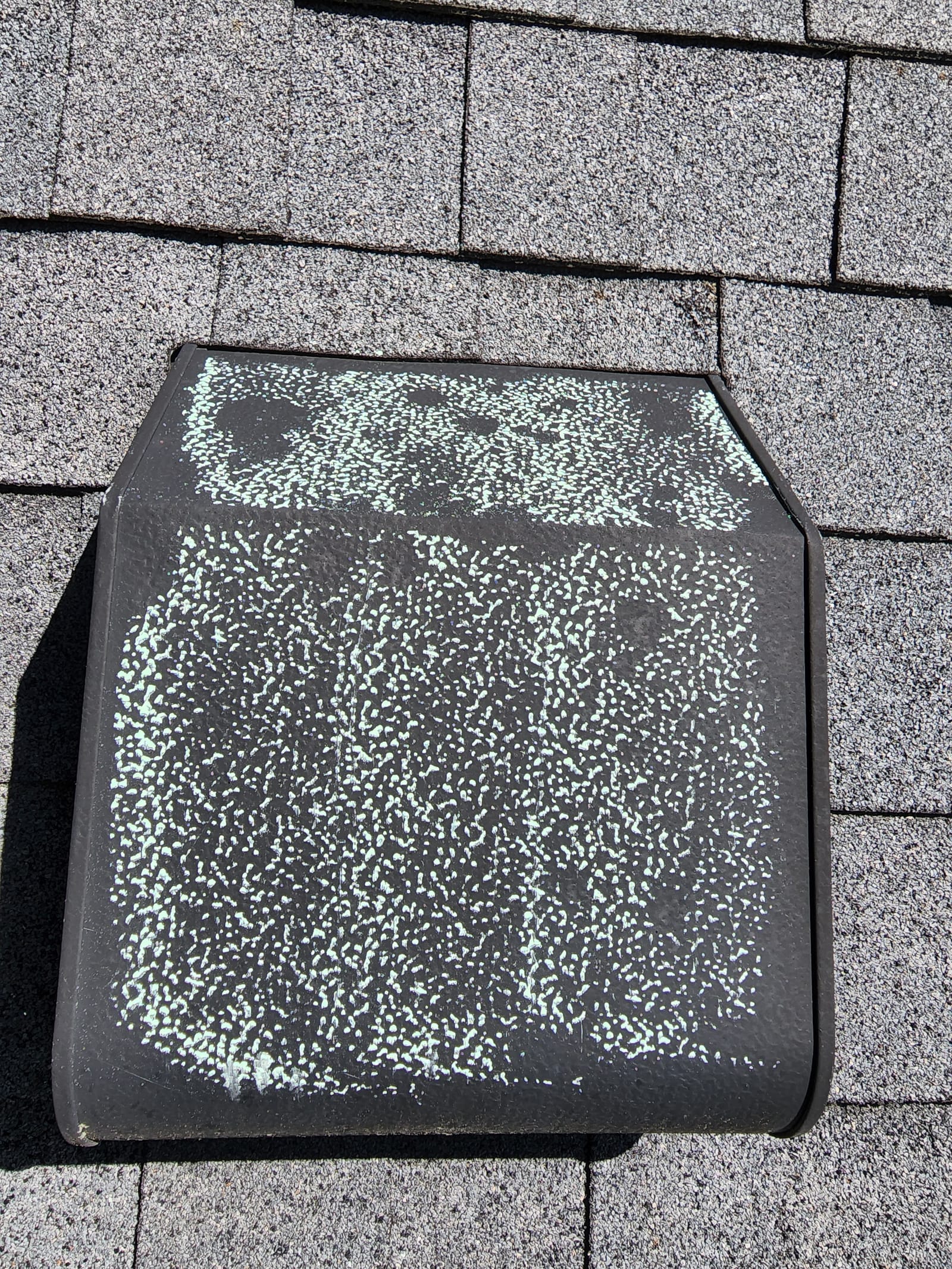 Close-up of hail damage on a roof vent