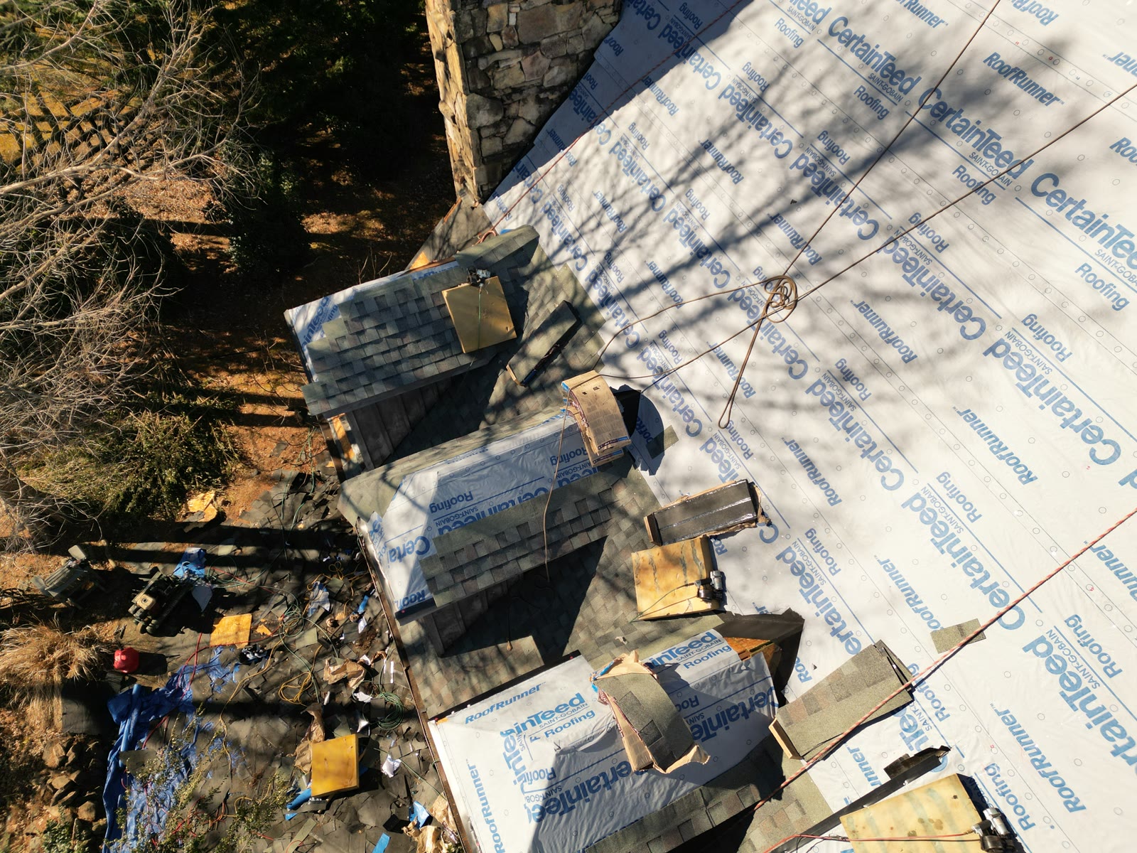 Aerial view of a RuFR USA roof replacement in progress on a Western North Carolina home, CertainTeed RoofRunner underlayment down and new shingles going on