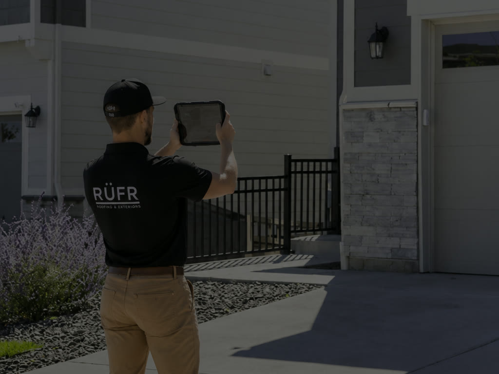 A RuFR USA inspector photographing a home on a tablet during a free roof inspection