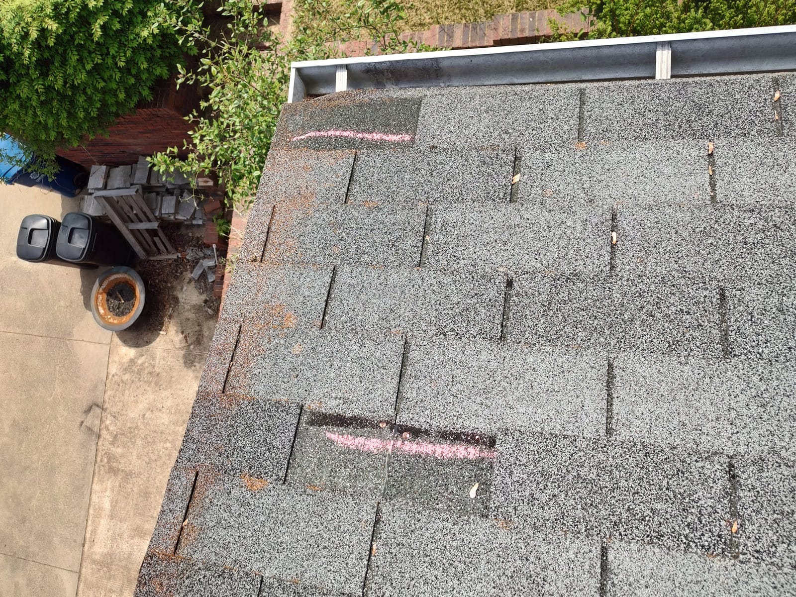Wind-damaged shingles chalk-marked during a roof inspection in Asheville, NC